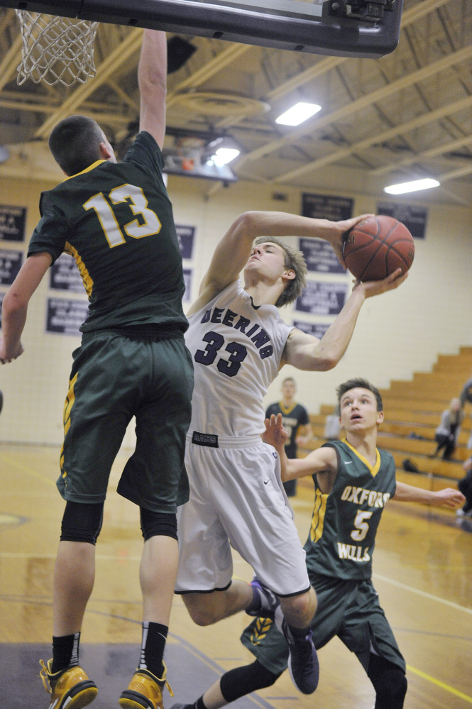 PORTLAND, ME - JANUARY 18: Deering vs. Oxford Hills boys basketball game. Deering’s #33, Orey Dutton, finds his drive to the basket blocked off by Oxford Hill’s #13, Matt Fleming.