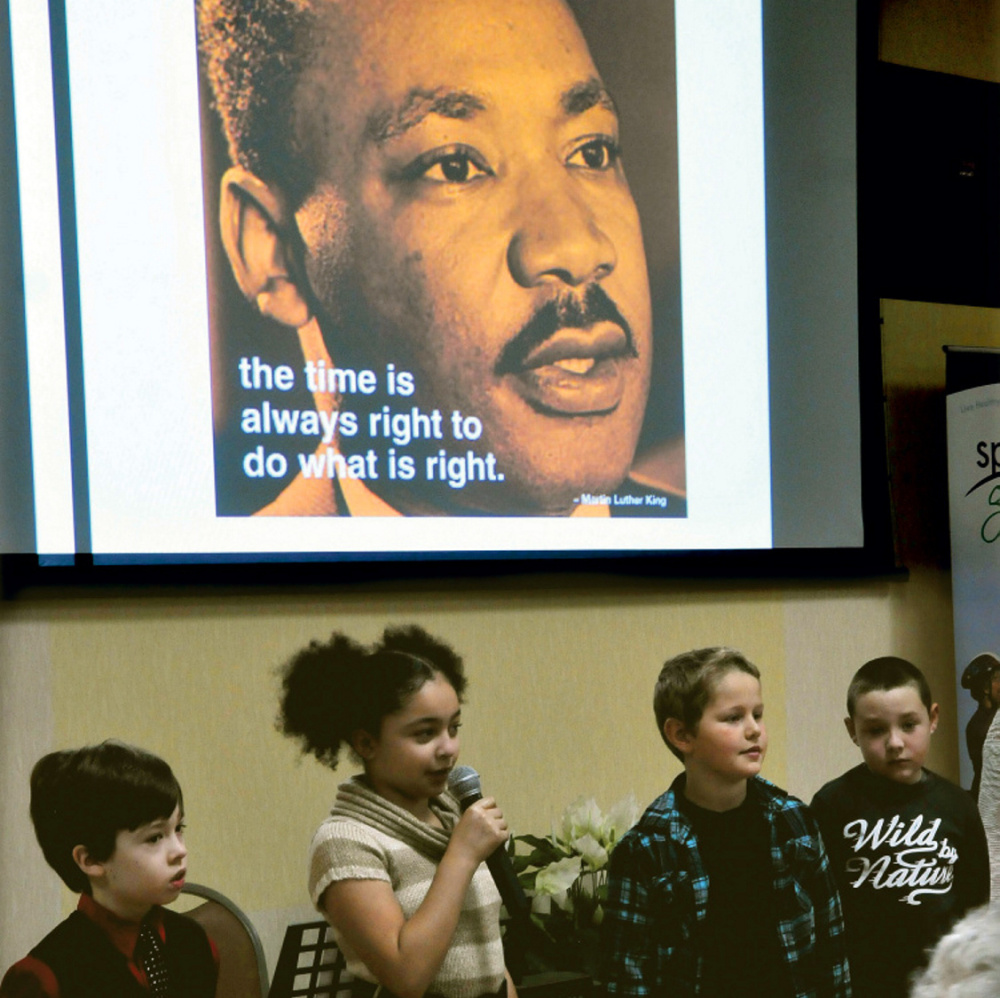 Students from George Mitchell School, including Isabella Bohner, center, recite passages Monday during the Martin Luther King Jr. breakfast celebration at the Muskie Center in Waterville.