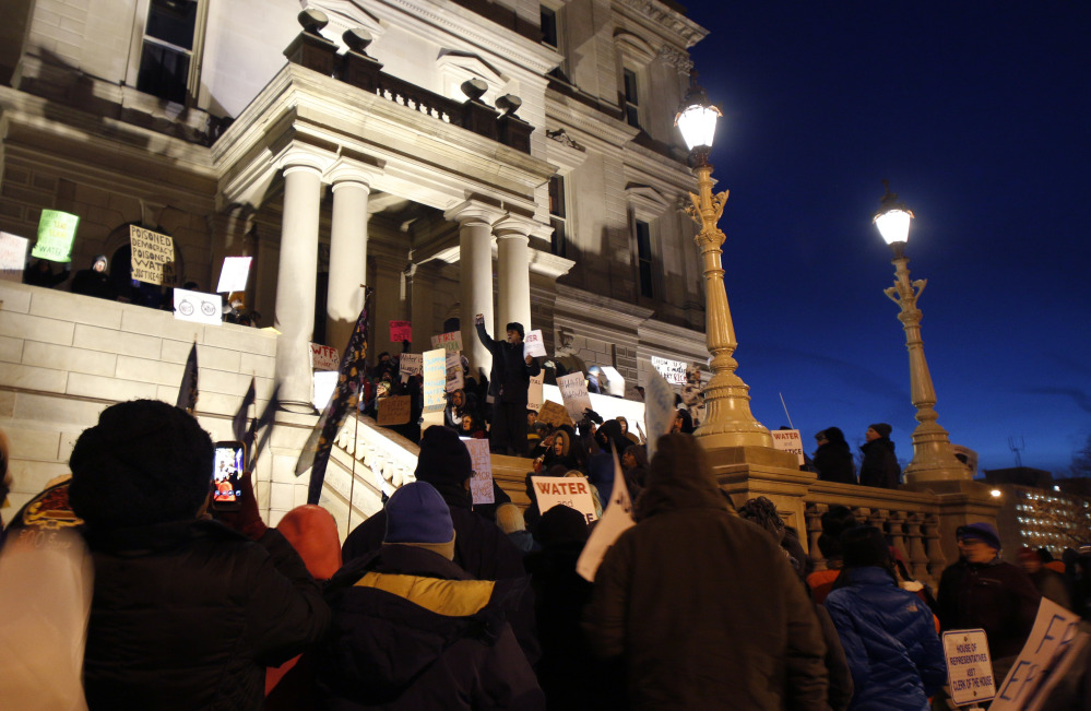 Protesters gather outside the state Capitol before Michigan Gov. Rick Snyder’s State of the State address Tuesday night in  Lansing, Mich., where the Flint water crisis threatens to overshadow nearly everything else he has accomplished.
