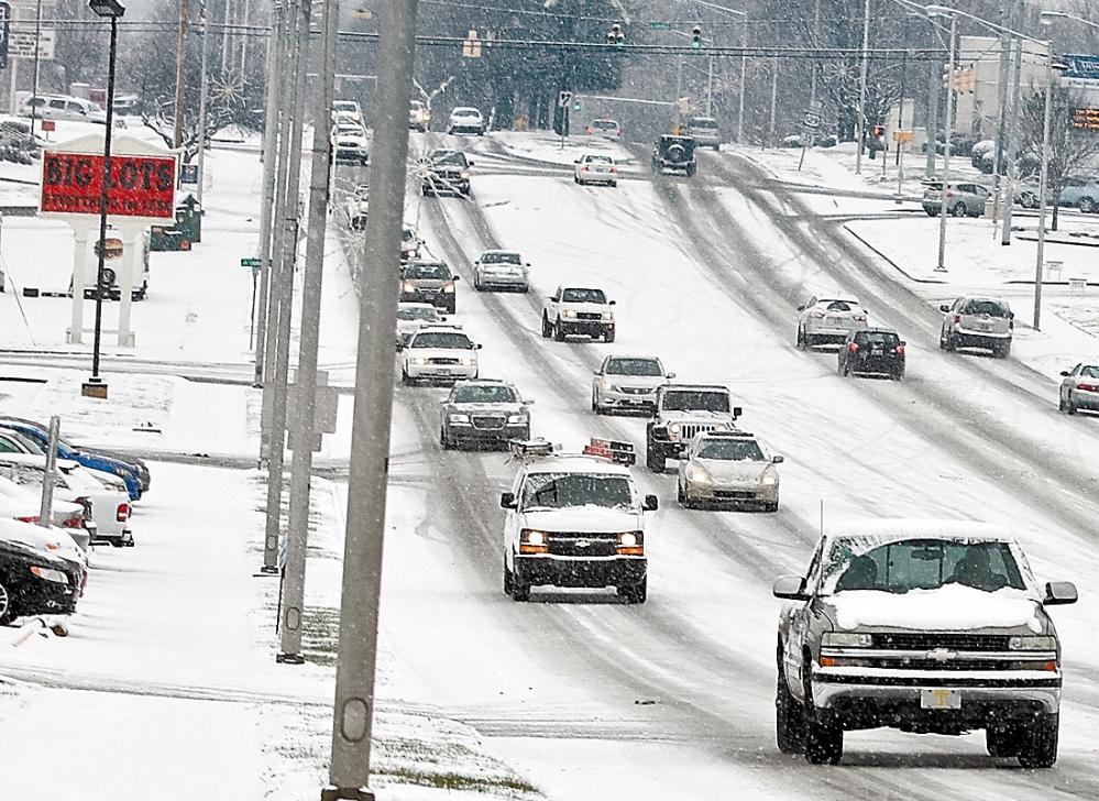 As snow falls, traffic moves slowly along slippery roads in Alcoa, Tenn., Wednesday. The South and East braced for blizzard conditions with the potential for significant snowfall by week’s end.