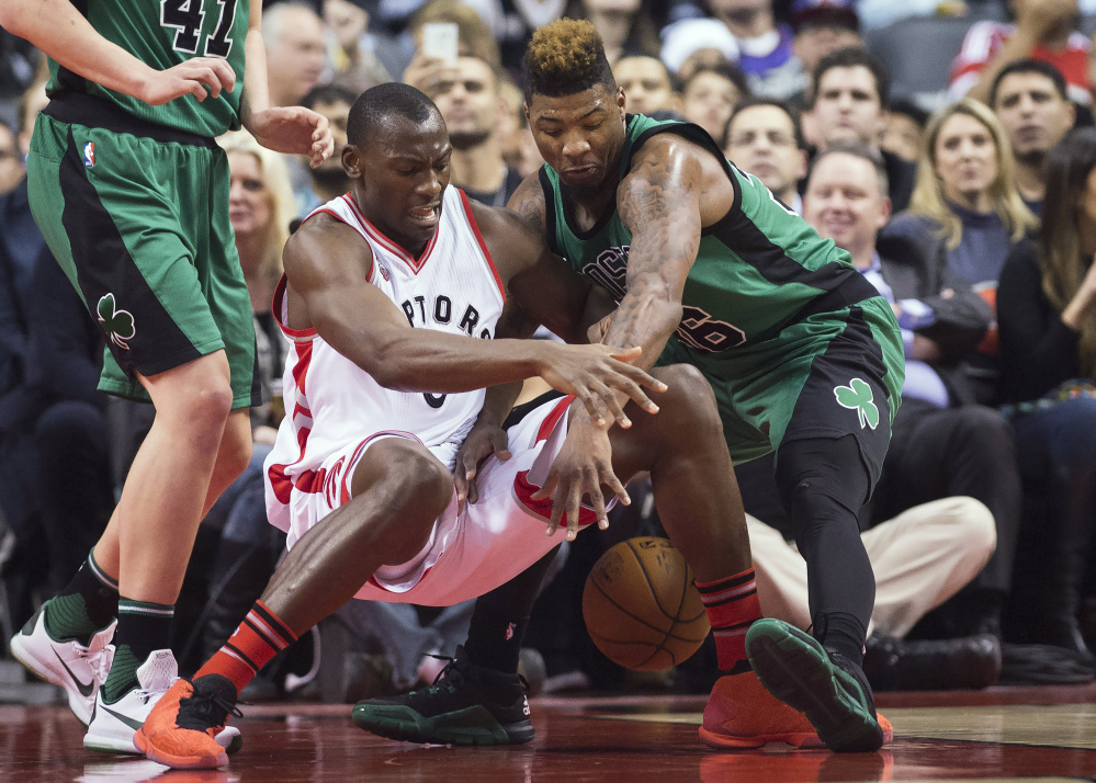 Toronto center Bismack Biyombo goes for a loose ball against Celtics guard Marcus Smart in the first half.