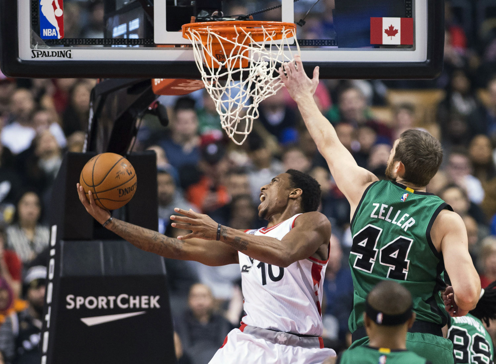 Raptors guard DeMar DeRozan gets past Celtics centre Tyler Zeller to score in the first half of Wednesday night’s game in Toronto. DeRozan scored 34 points in Toronto’s 115-109 win.