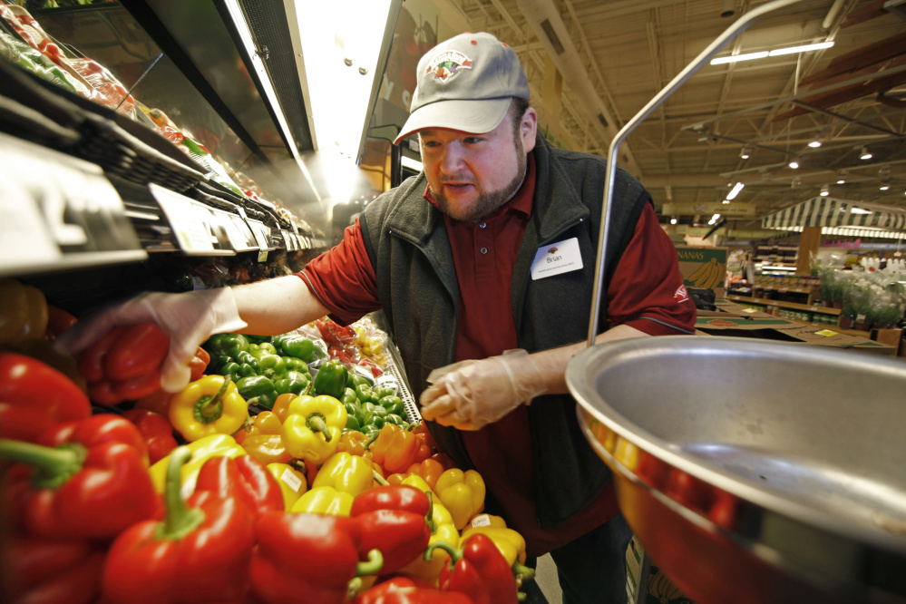 Brian Cunningham, produce shift leader, sorts through peppers and other vegetables to cull those to be donated to local food pantries, a daily duty at Hannaford in Westbrook. Jill Brady/Staff Photographer