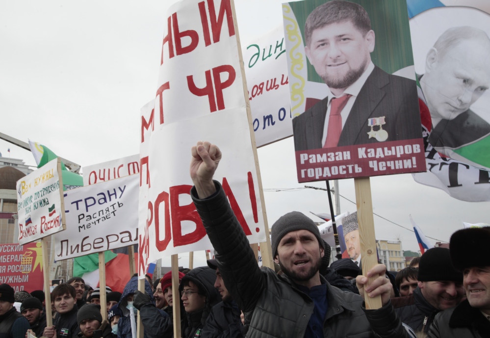Chechen demonstrators hold portraits of Russian President Vladimir Putin and Chechen regional leader Ramzan Kadyrov as they listen to an orator during a massive rally in Grozny, Russia, on Friday.