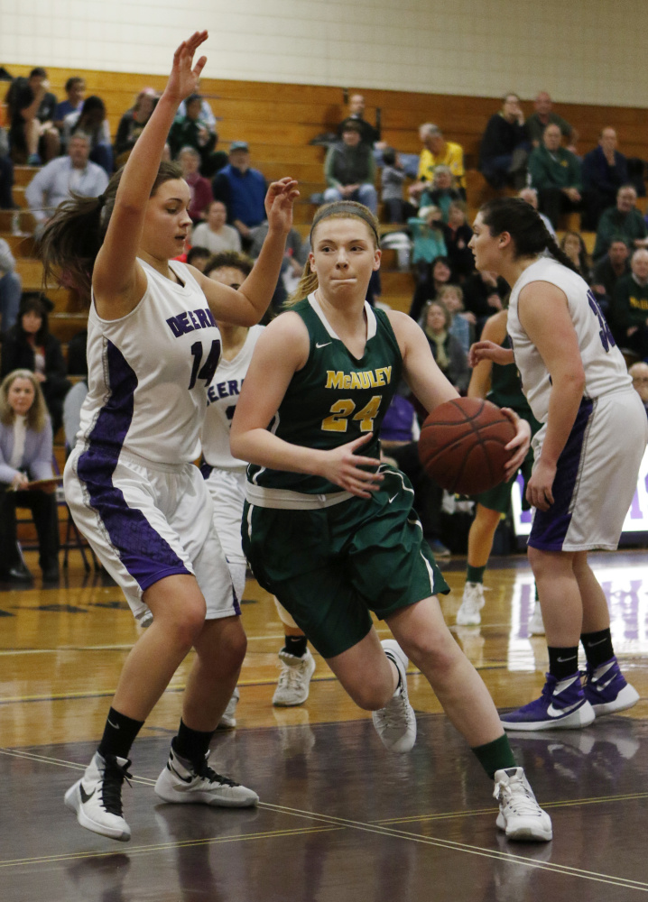 McAuley’s Emily Weisser, center, drives to the basket while being guarded by Deering’s Delaney Donovan, left, during the Lions’ 52-43 win Friday at Deering.
Joel Page/Staff Photographer