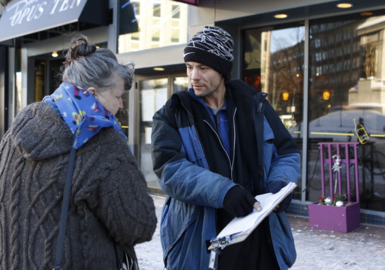Brandon Scott, right, speaks with Joyce Lorraine, as he works to collect signatures on a petition about a casino referendum on Thursday  in Monument Square in Portland,.
Joel Page/Staff Photographer
