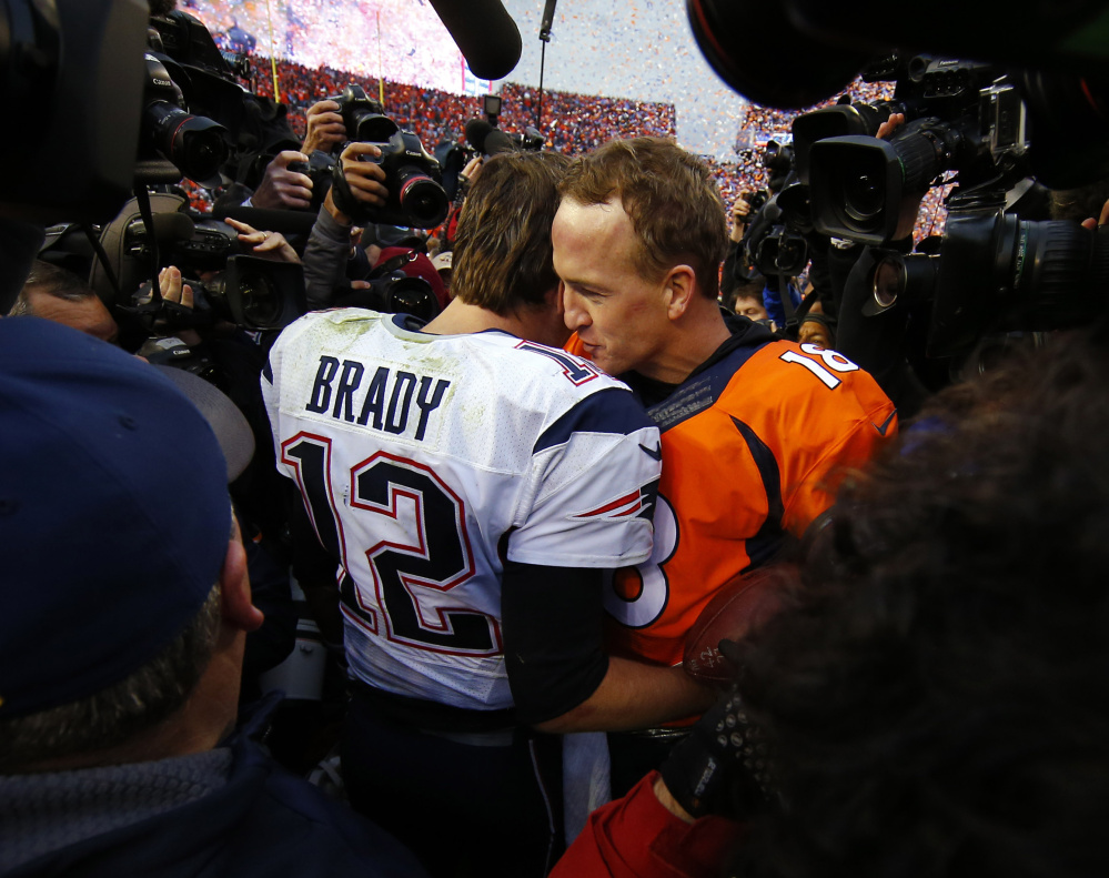At top, a bleeding and battered Tom Brady gets up after yet another hit in the second half of the AFC title game. Above, he talks with Denver’s Peyton Manning after the Broncos’ 20-18 victory. More coverage in Sports, C1
