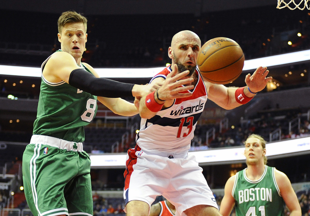 Wizards center Marcin Gortat reaches for the ball as Celtics forward Jonas Jerebko looks on in the first half of Monday night’s game.