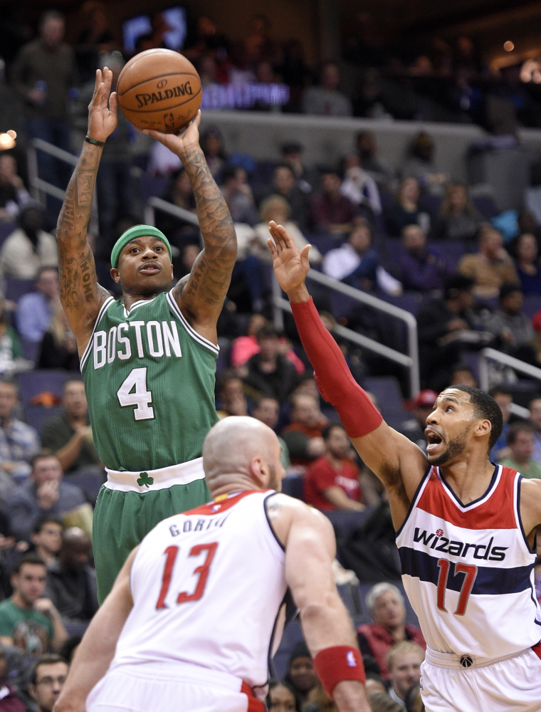 Celtics’ guard Isaiah Thomas takes a shot against Wizards guard Garrett Temple, right, and center Marcin Gortat during Boston’s 116-91 win Monday in Washington.