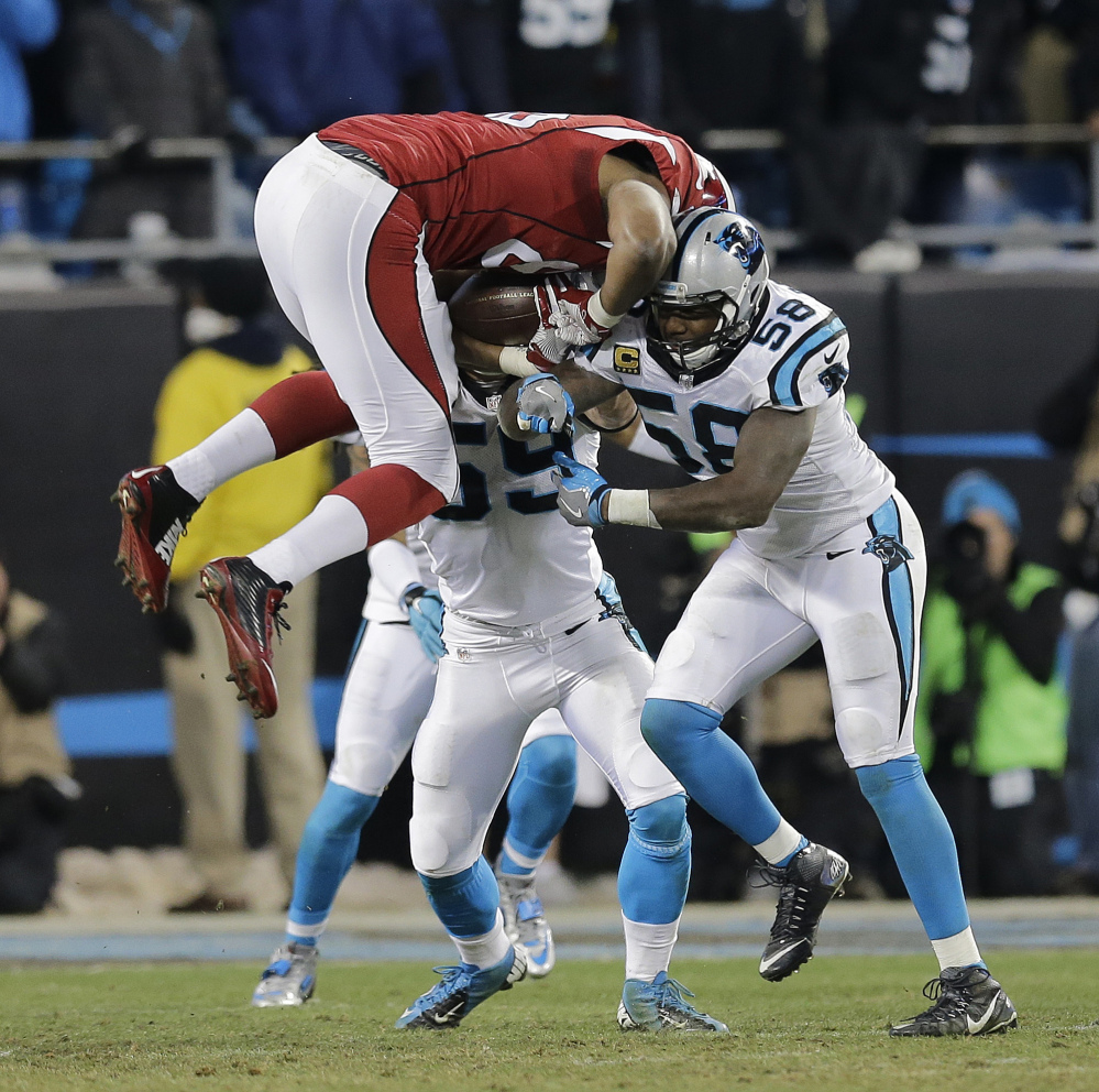 Arizona Cardinals’ Darren Fells is hit by Carolina Panthers’ Thomas Davis (58) and Luke Kuechly after catching a pass during the first half the NFL football NFC championship game Sunday in Charlotte, N.C. 
