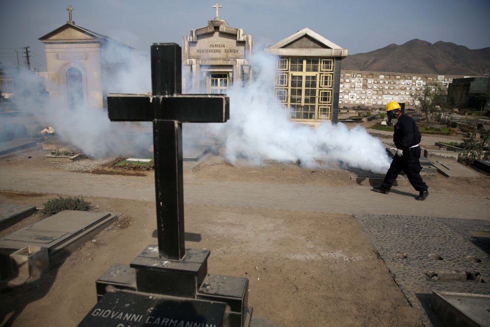 A health worker fumigates to prevent Dengue, Chikunguya and Zika virus, at a cemetery in Lima, Peru.