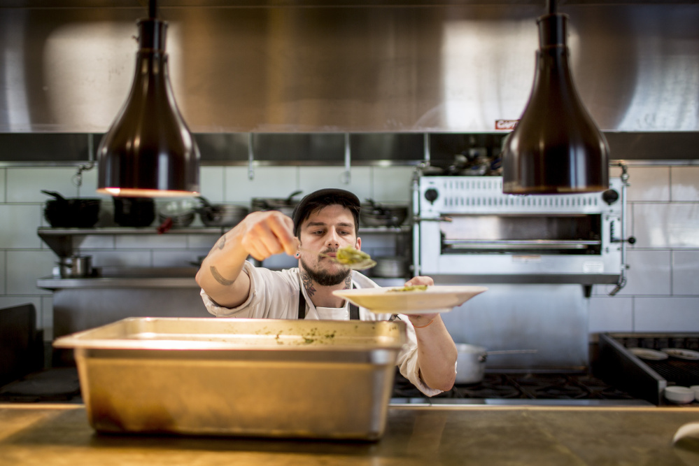 Adam Heath, kitchen manager and grill cook at Tiqa, helps himself to a serving of pesto chicken penne.
