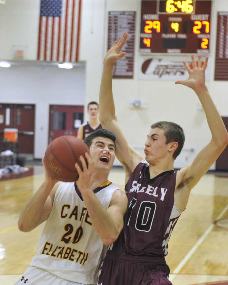 Cape Elizabeth’s Justin Guerette, left, drives to the basket against Greely’s Ryan Twitchell during the Capers’ 45-38 win Monday in Cape Elizabeth.