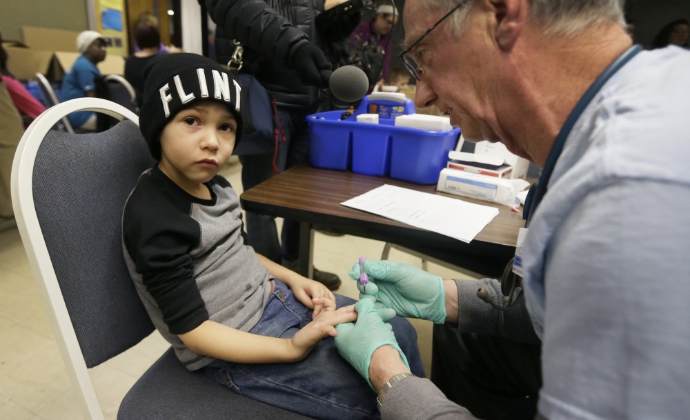 Brian Jones, a nurse, draws a blood sample from Grayling Stefek, 5, at the Eisenhower Elementary School on Tuesday in Flint, Mich. The students were being tested for lead.