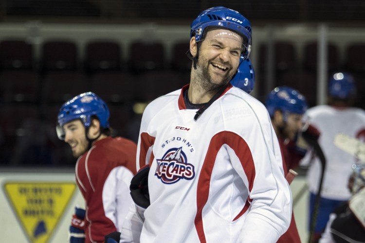 John Scott laughs with his AHL teammates as the St. John’s IceCaps practice Tuesday in Portland. A social media prank led to his election as a team captain at the NHL All-Star Game this weekend.