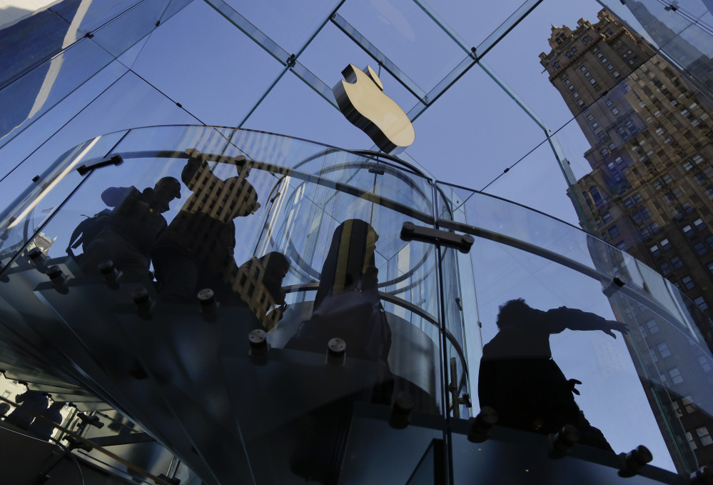 In this Sept. 19, 2014, file photo, a group of visitors to the Apple store descends a staircase to the showroom below in New York.