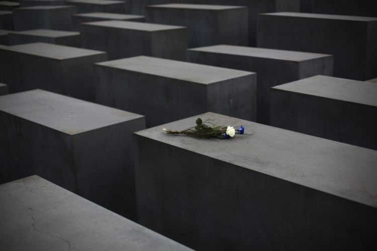 Flowers lay on a slab of the Holocaust Memorial to commemorate the victims of the Nazi regime at the International Holocaust Remembrance Day in Berlin, Wednesday.