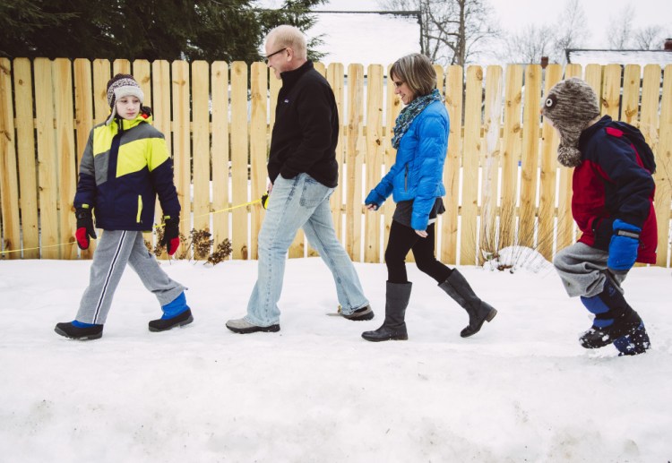Aidan Wood, 11, his parents, David Wood and Heather Moore Wood, and his brother Ellis, 7, walki in Portland on Wednesday. When the Woods bought their house, they specifically sought a walkable neighborhood.