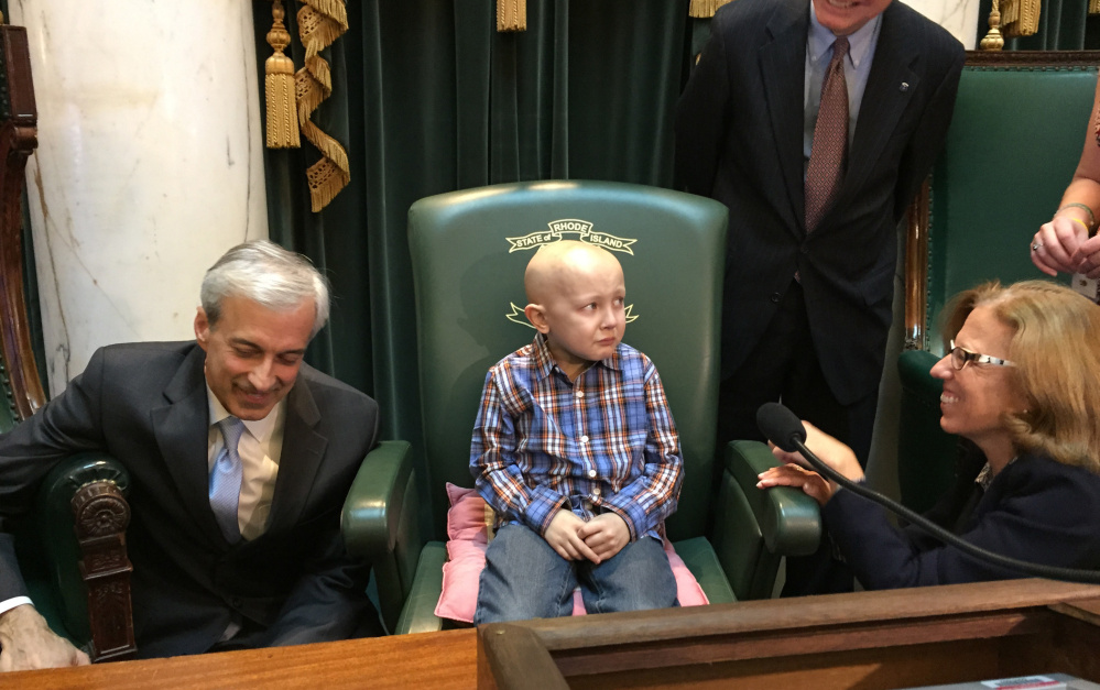 Dorian Murray, 8, of Westerly, R.I., is a bit overwhelmed as he sits in the Statehouse Senate Chamber in Providence, R.I., Wednesday, Jan. 20, 2016 as he is honored by Rhode Island lawmakers, from left, Majority Leader Dennis Algiere, State Rep. Brian Kennedy and Senate President Teresa Paiva Weed, who proclaim it “#DSTRONG Day” in a general assembly resolution. Murray, who has a rare and untreatable form of pediatric cancer, has said his final wish was to become famous in China.
