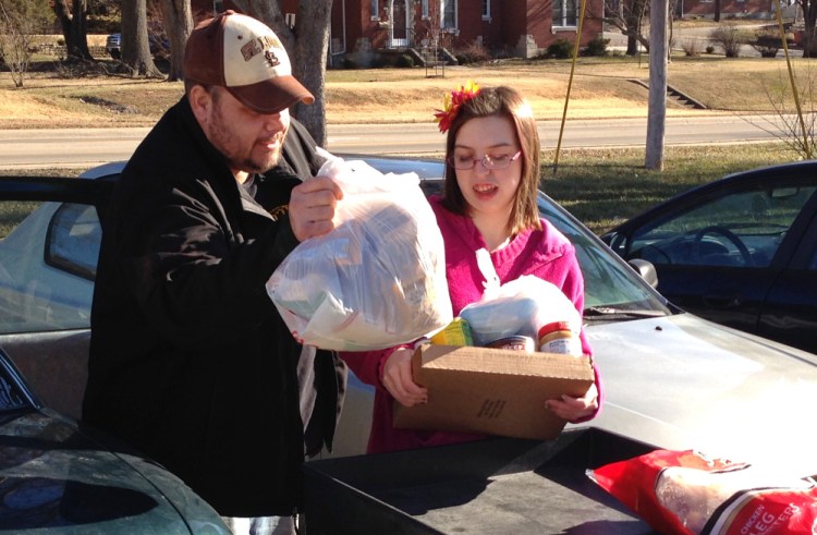  Joe Heflin, left, of Jefferson City loads free groceries into the backseat of his car with the help of a volunteer at the Samaritan Center food pantry in Jefferson City, Mo. Heflin, 33, also receives federally funded food stamp benefits.