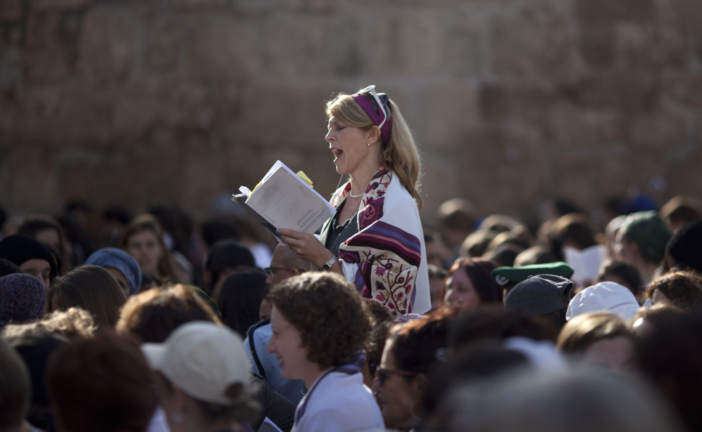 A Jewish woman wears a prayer shawl as she prays at the Western Wall, the holiest site where Jews can pray in Jerusalem’s Old City.