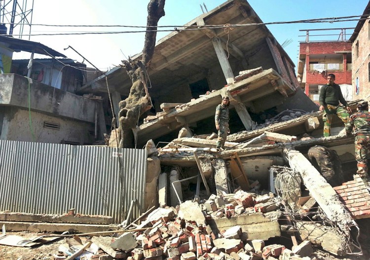 Indian soldiers inspect a house that collapsed in an earthquake in Imphal, capital of the northeastern Indian state of Manipur, where a severe earthquake hit the remote northeast region before dawn on Monday. The Associated Press