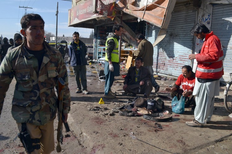 Pakistani police  and rescue workers gather at a polio vaccination center in southwestern Pakistan – the site of a suicide bombing that killed 15 people. The Associated Press
