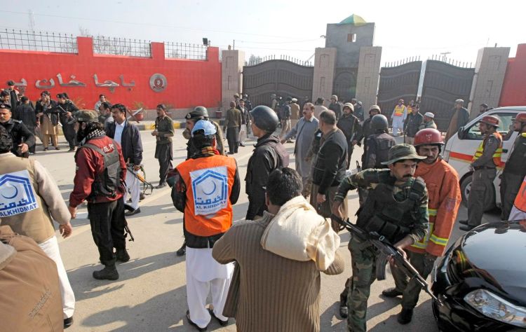 Troops and rescue workers gather at the main gate of Bacha Khan University in Charsadda town, 21 miles outside the city of Peshawar, Pakistan, Wednesday. Gunmen stormed the university, which is named after the founder of an anti-Taliban political party. The Associated Press