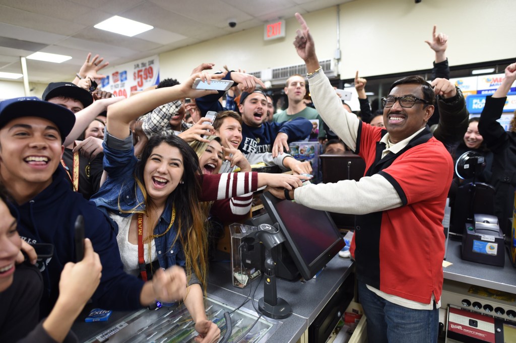 7-Eleven clerk M. Faroqui celebrates with customers Wednesday after learning the Chino Hills, Calif., store sold a winning Powerball ticket.  One winning ticket. Will Lester/The Sun via AP