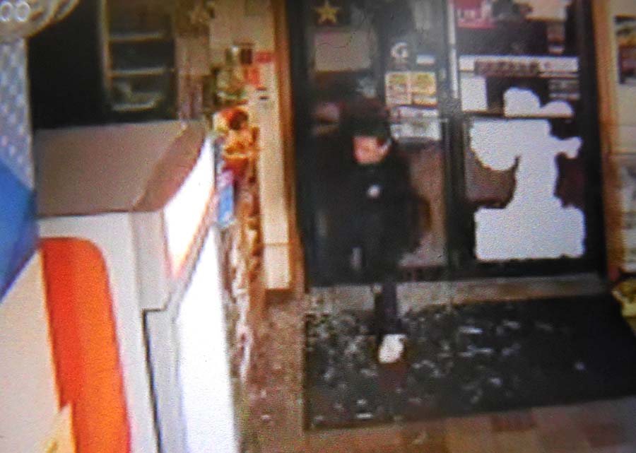 A burglar enters Riverton Gas at 1585 Forest Ave. after breaking through the store's glass door. Surveillance image provided by Portland Police Department