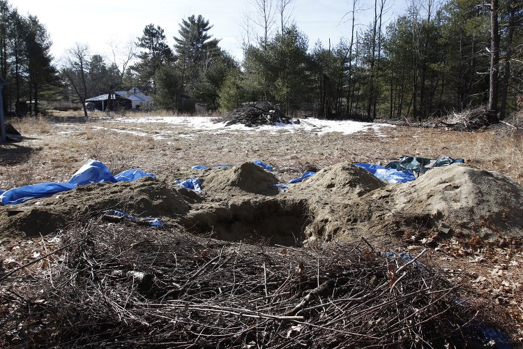 A hole is seen behind the home of Shawn Farnell Tuesday in Baldwin, Maine. Joel Page/Staff Photographer