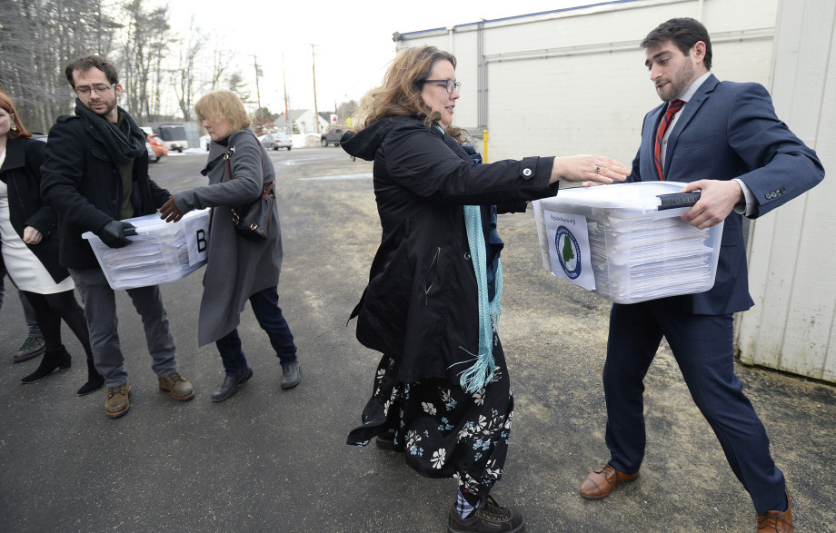 David Boyer, manager of the Campaign to Regulate Marijuana Like Alcohol, passes a box of petitions to Rep. Diane Russell as they prepare for a trip to Augusta to submit them to the Secretary of State’s Office in February.
