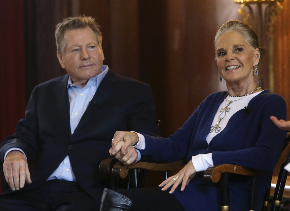 Actors Ryan O’Neal and Ali MacGraw hold hands as they are introduced for a talk with students at Harvard.