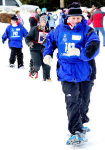 Jaimi Buck of Work First in Farmington strides to a win in her 50-meter snowshoe time trial at the 2016 Special Olympics Maine Winter Games at Sugarloaf on Monday. At far left is team member Noele Brown.