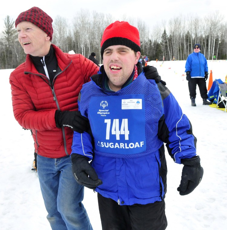 Work First’s Mark Gordon is assisted by Randy Judkins after the 100-meter snowshoe race. Other competitions are in alpine and Nordic skiing and speed skating.