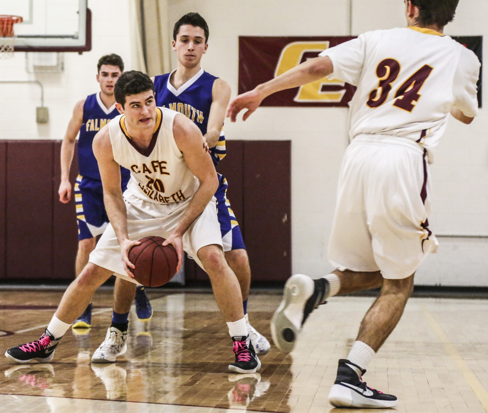 Justin Guerette of Cape Elizabeth keeps an eye on teammate Nate Ingalls before passing Tuesday night. Tyler Gee, behind Guerette, and Sam Skop defend for Falmouth, which collected a 44-42 victory on the road.