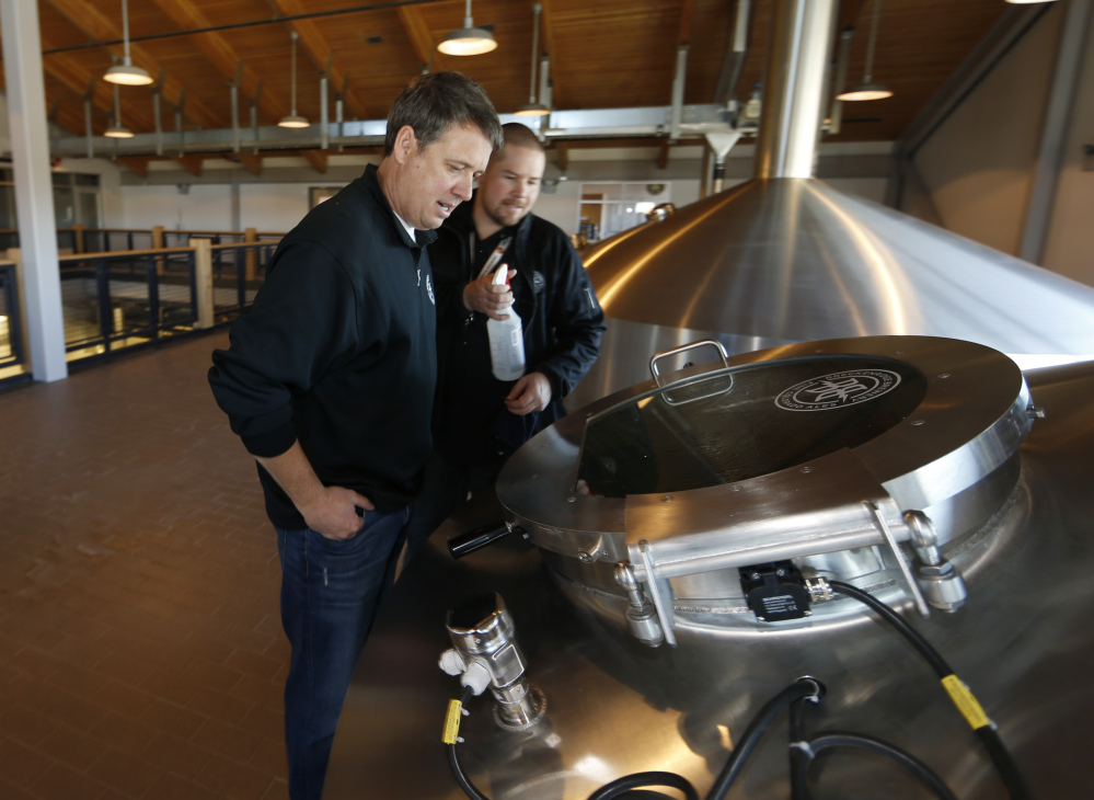 Todd Usry, front, chief of Breckenridge Brewery, checks over beer brewing in the company’s factory in Littleton, Colo. The entry of Anheuser-Busch InBev into Colorado’s craft beer paradise has some brewers worried that the world’s largest brewer could squeeze independent makers out of the booming industry. (AP Photo/David Zalubowski)