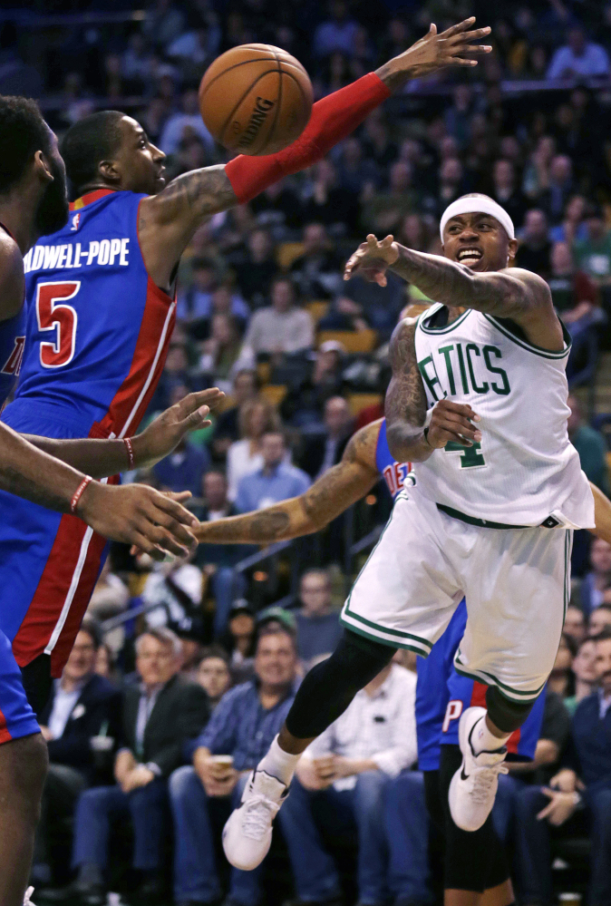 Boston Celtics guard Isaiah Thomas, right, passes the ball as he is pressured by Detroit Pistons guard Kentavious Caldwell-Pope (5) during the first quarter.