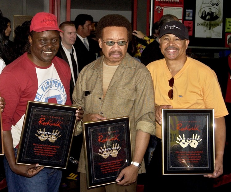 Philip Bailey, left, Maurice White, center, and Ralph Johnson of Earth Wind & Fire hold up the plaques from their induction to the Hollywood Rock Walk at a ceremony in Los Angeles in 2003. White, the founder and leader of Earth, Wind & Fire, died at home in Los Angeles on Wednesday at 74.
