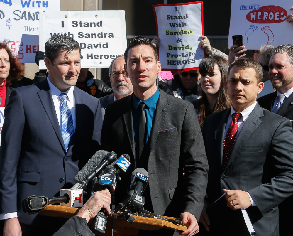 David Daleiden, center, an anti-abortion activist indicted last week in Houston, speaks to the press on Thursday. He plans to reject a plea deal that would essentially get him probation for tampering with a governmental record.