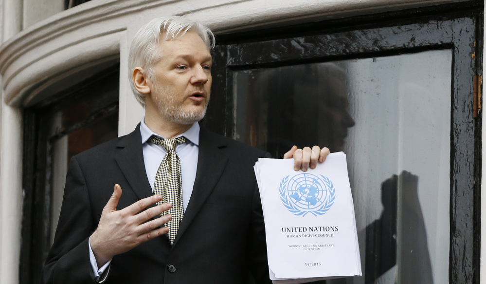 Wikileaks founder Julian Assange holds a U.N. report issued Friday that says he has been arbitrarily detained in the Ecuadorean Embassy in London.