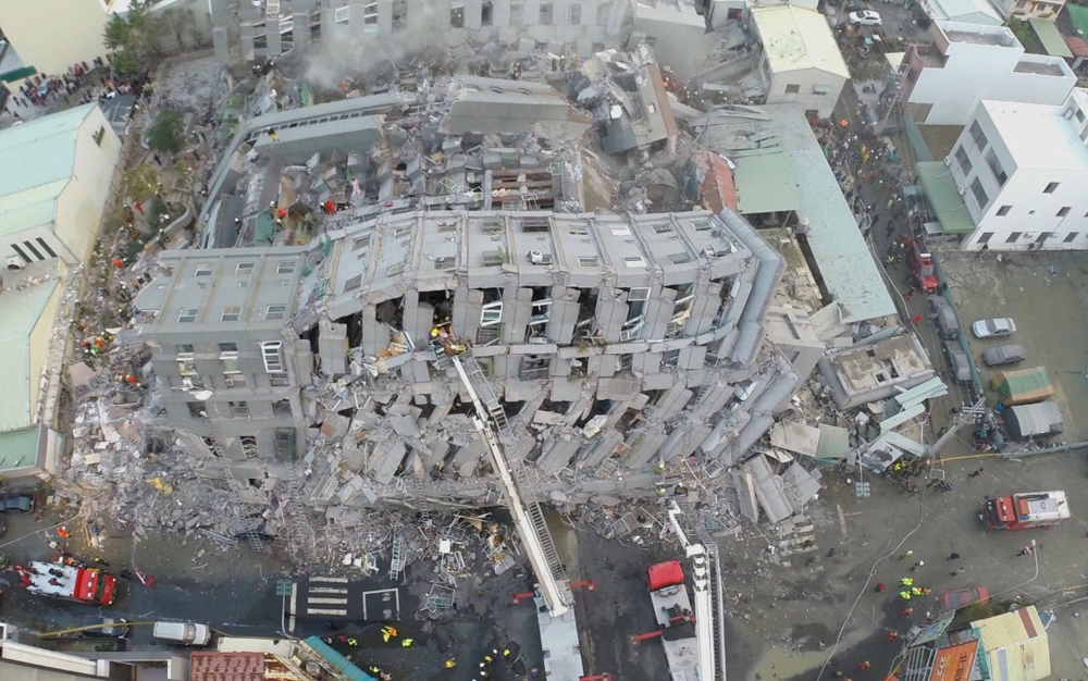 In this photo taken from a drone mounted camera, rescue workers search a collapsed building from an early morning earthquake in Tainan, Taiwan, on Saturday.