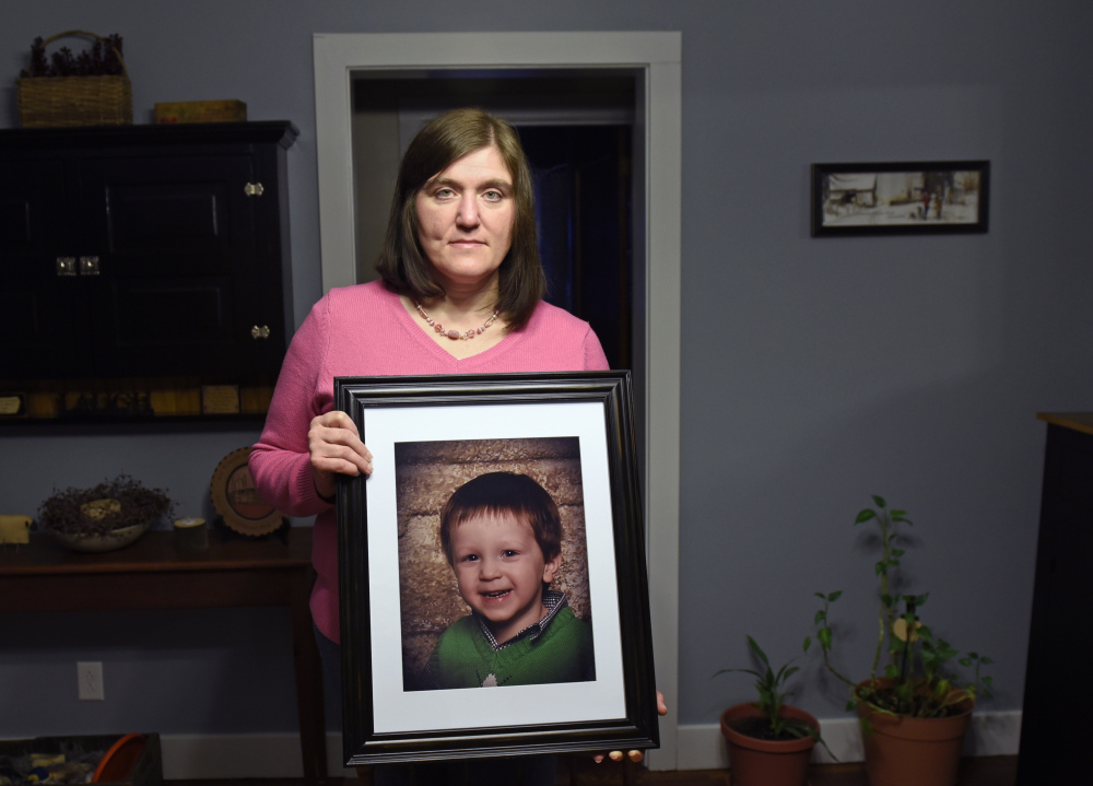Shot and wounded herself by an abusive ex-husband who then committed suicide, Hollie Ayers poses with a photograph of her late son, Michael, 2, who was slain during the 2013 rampage at her home in Bedford, Pa.