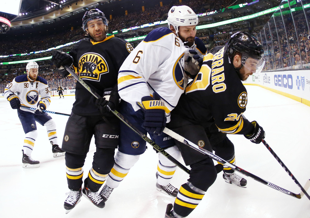 Buffalo’s Mike Weber, center, gets caught between Boston’s Max Talbot, left, and Landon Ferraro during the second period of the Bruins’ 2-1 overtime win Saturday in Boston.