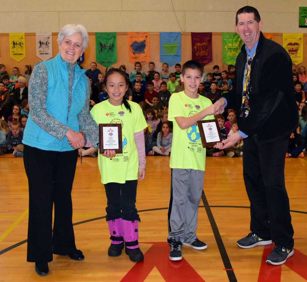 Wells Elementary School Principal Marianne Horne, left, and Assistant Principal Ken Spinney present recognition plaques to fourth-graders Maya Grainger and Colton Harding for their first-place finishes in the American Heart Association’s 2015 Jump Rope for Heart fundraiser.