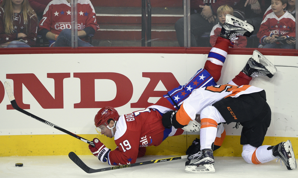 Washington Capitals center Nicklas Backstrom, left, is upended during a battle for the puck against Philadelphia Flyers center Nick Cousins during the third period of a 3-2 win by the Capitals on Sunday afternoon at Washington.