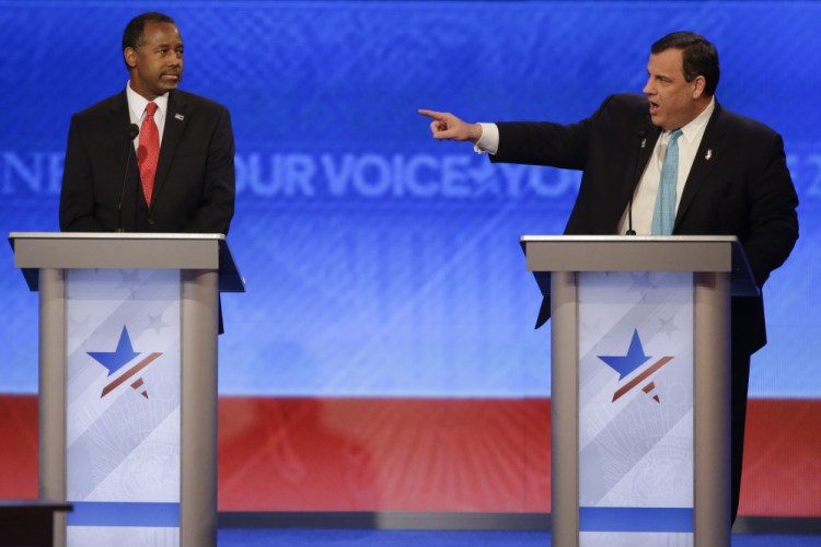 Republican presidential candidate Chris Christie points beyond Ben Carson to Marco Rubio (not shown), accusing the Florida senator of repeating a rehearsed 25-second speech during the Republican debate Saturday night.