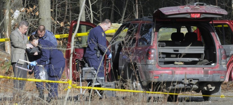 Maine State Police detectives examine the SUV containing the bodies of Eric Williams and Bonnie Royer, who were found dead on Sanford Road in Manchester early Christmas Day.