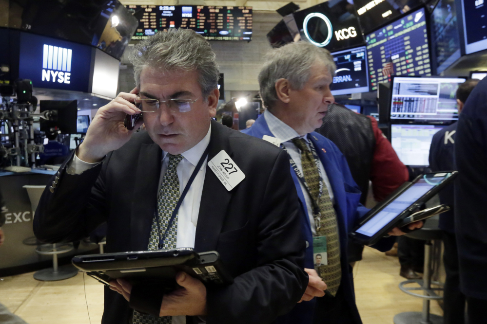 Traders John Bishop, left, and Richard Newman work on the floor of the New York Stock Exchange, Monday.