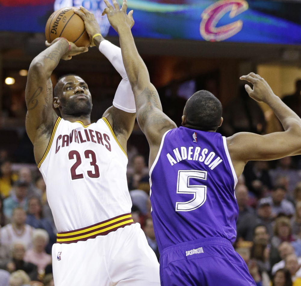 Cleveland’s LeBron James shoots over Sacramento’s James Anderson in the first half of Cleveland’s 120-110 win Monday in Cleveland. James finished with a triple-double.